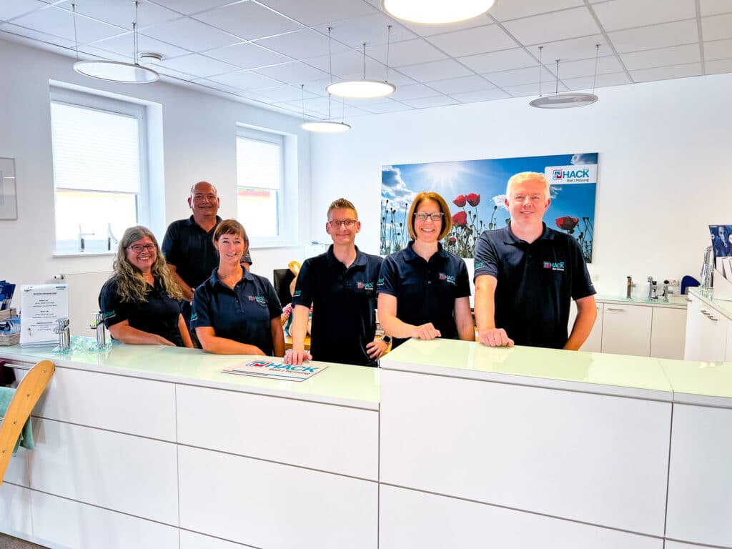 Teamfoto im modernen Büro mit Empfangstresen.