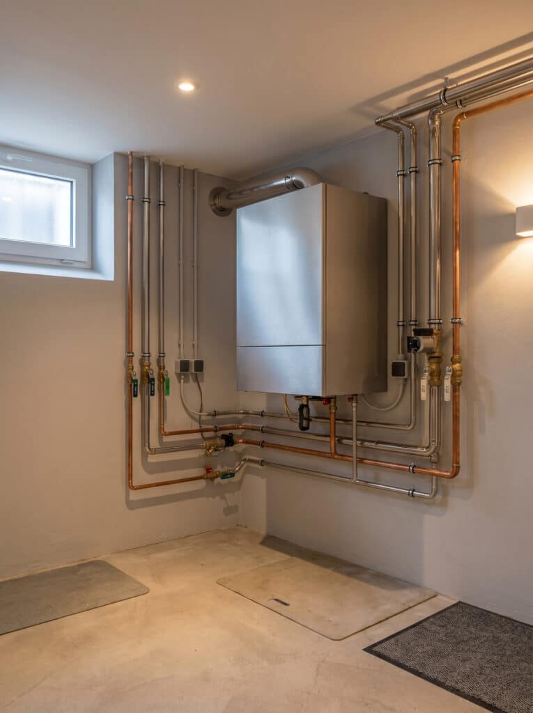 Moderne Gastherme mit sichtbaren Kupferrohren im Keller
